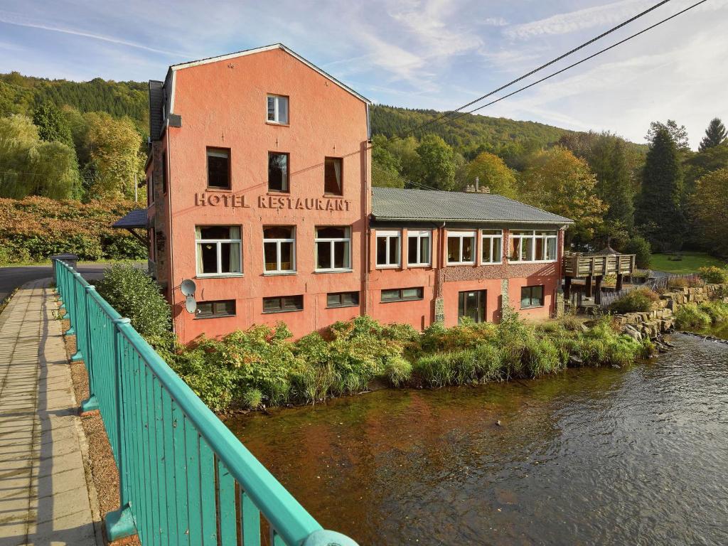a building on a bridge next to a river at Luxurious Mansion in Stoumont with Indoor Pool in Stoumont
