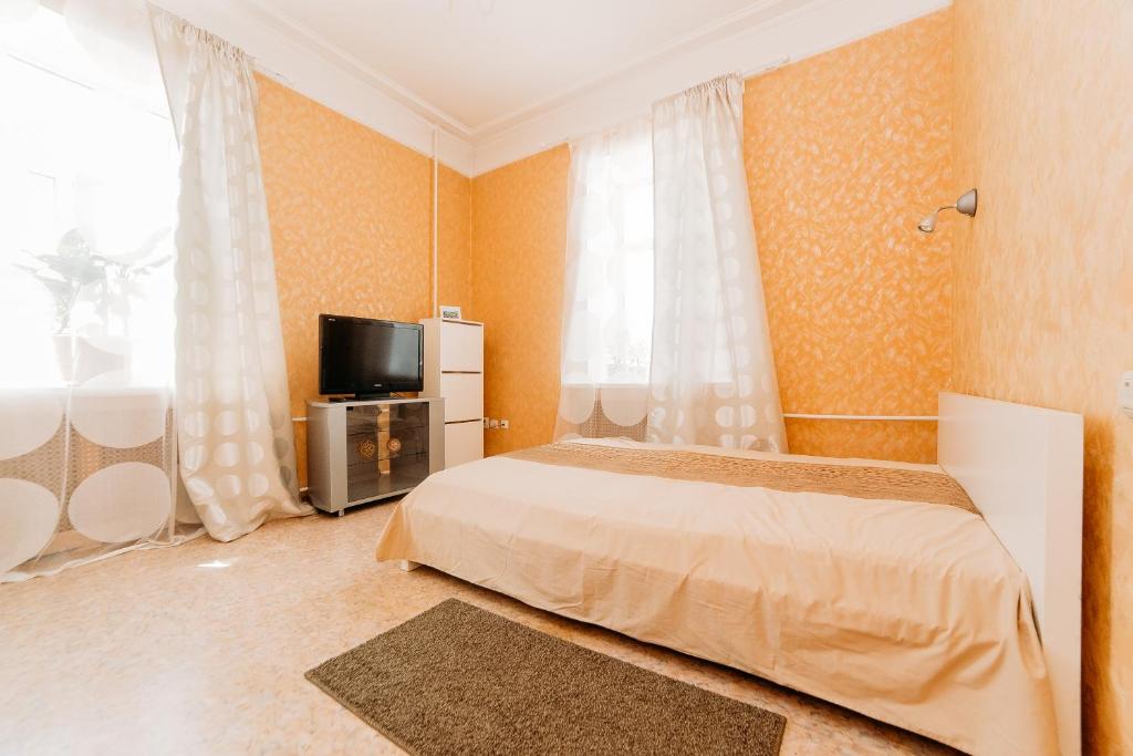 um quarto com uma cama e uma televisão de ecrã plano em Apartment Peshekhodnaya ul. Baumana em Kazan