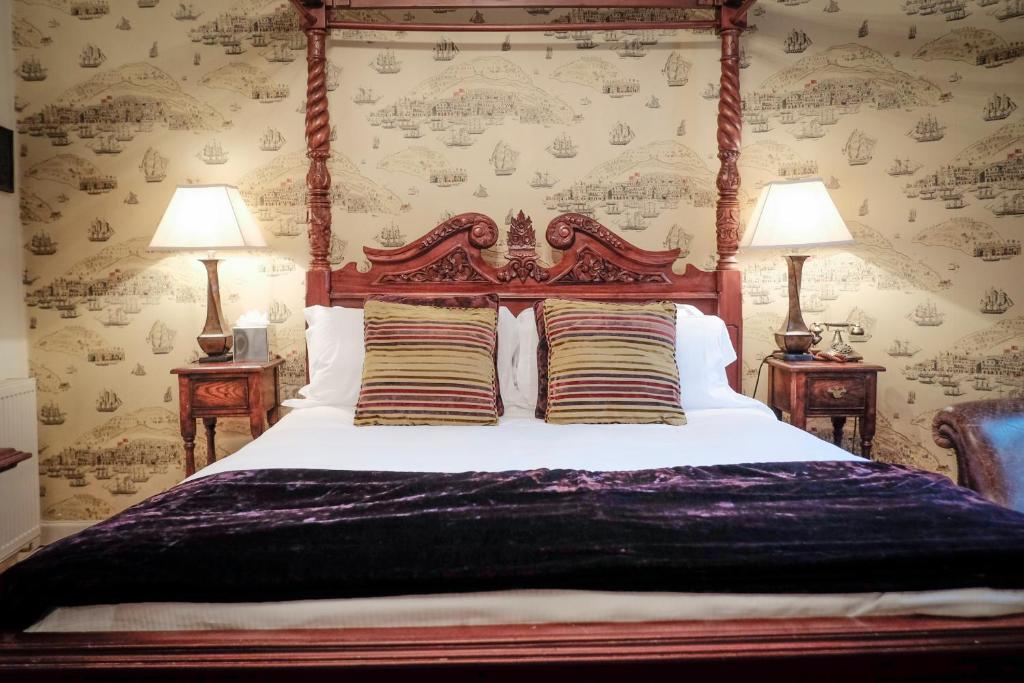 a bedroom with a large bed with two lamps at Wykeham Arms in Winchester