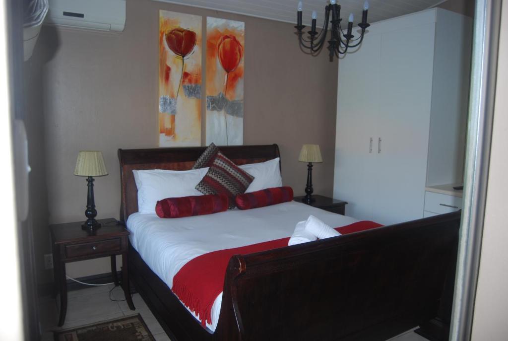 a bedroom with a bed with red pillows at de Charmoy Riverside in Durban