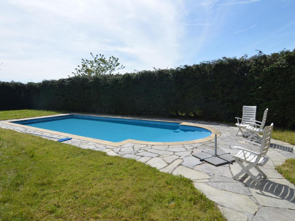 una piscina con 2 sillas de césped y un patio en Apartment with pool and sauna, en Felenne