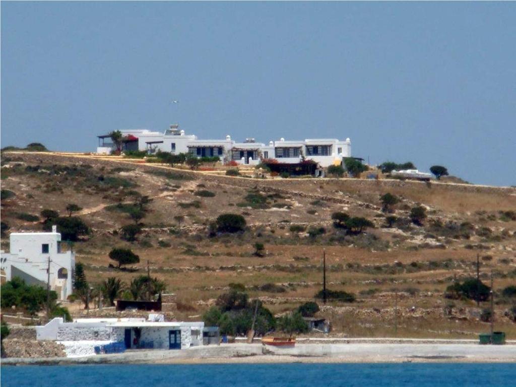a group of houses on a hill next to the water at Alkionides Studios in Koufonisia
