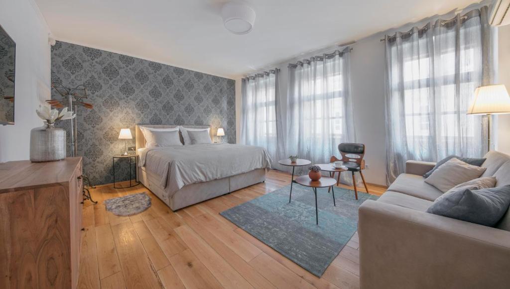 a bedroom with a bed and a couch at Apartment The 29 in Zagreb