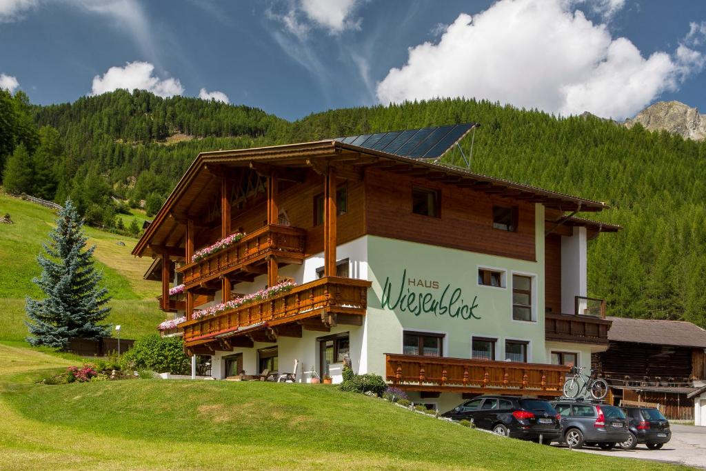 a large building with cars parked in front of it at Haus Wiesenblick in Sölden