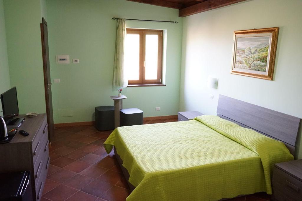 1 dormitorio con 1 cama y TV en La Luna nel Pozzo, en Riofreddo