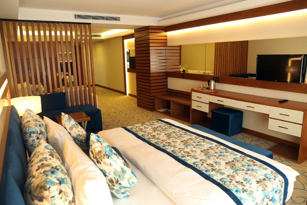 a hotel room with a large bed and a television at Yol Is Holiday Trabzon in Trabzon