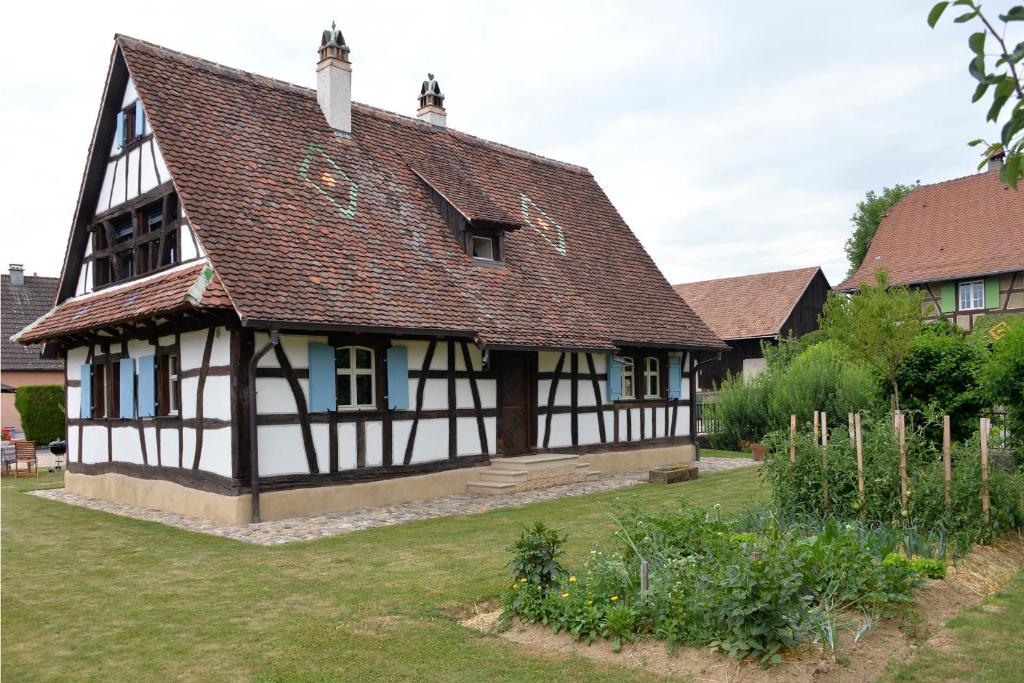 una vecchia casa con tetto marrone e cortile di Les colombages d'a cote a Stetten