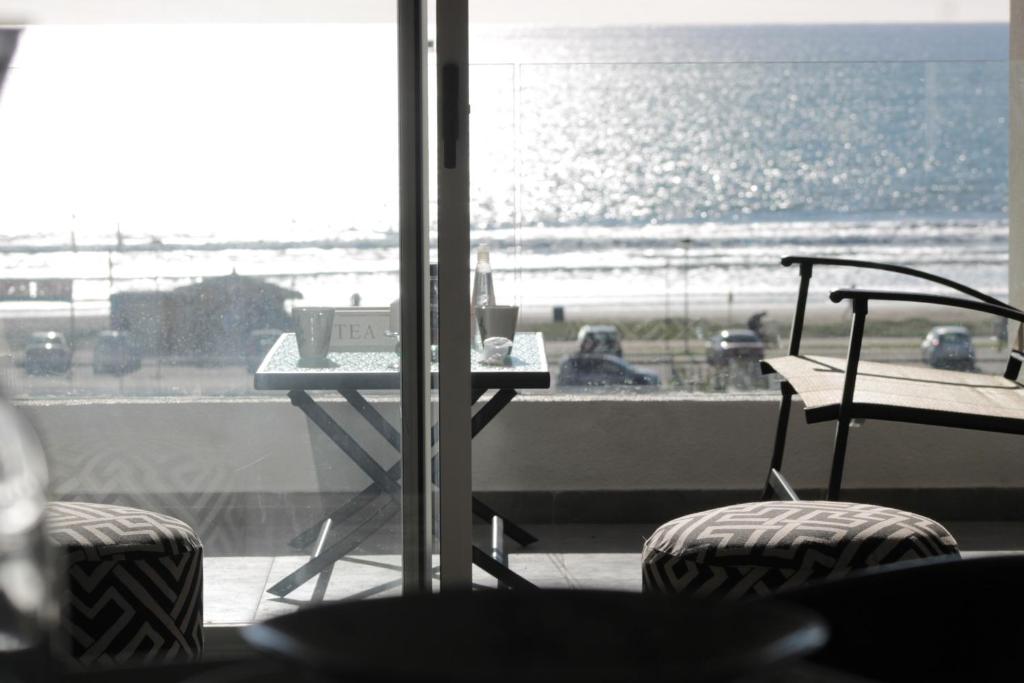 una mesa y sillas en una habitación con vistas al océano en Departamento en avenida del mar, en Coquimbo