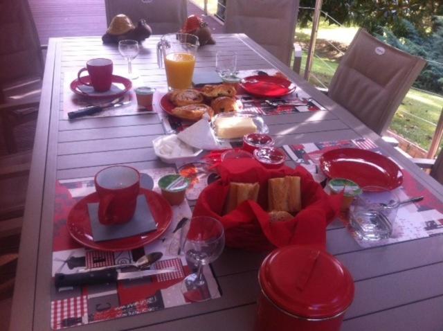 a table with red plates and food on it at le jardin d Eau in Lamothe-Montravel