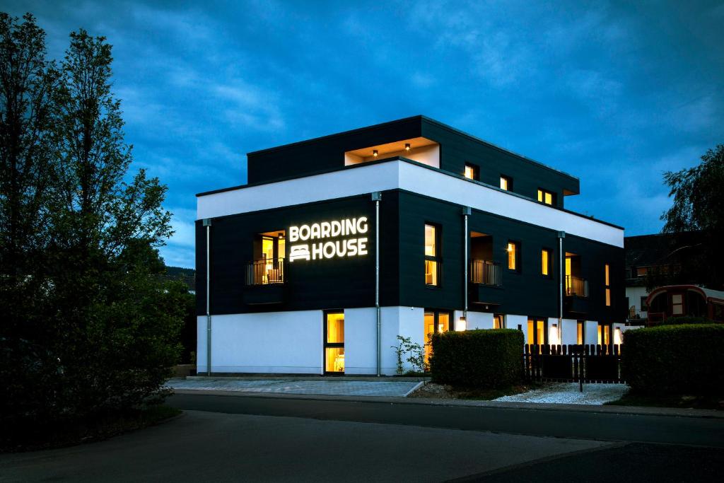 een zwart-wit gebouw met een bord erop bij Boardinghouse Morbach in Morbach