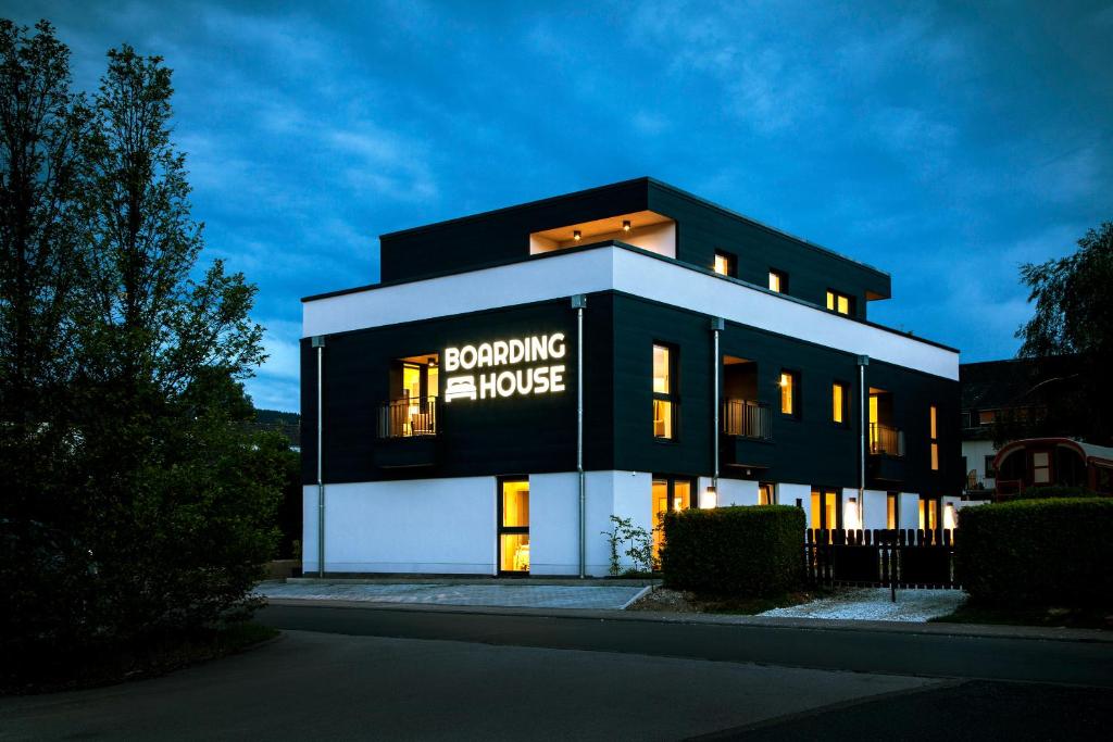 un edificio blanco y negro con un letrero. en Boardinghouse Morbach, en Morbach