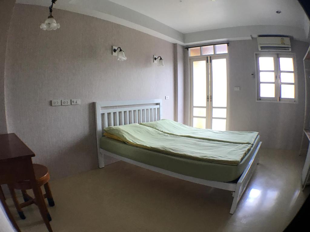 a small bedroom with a bed with a window at Roof View Place in Bangkok