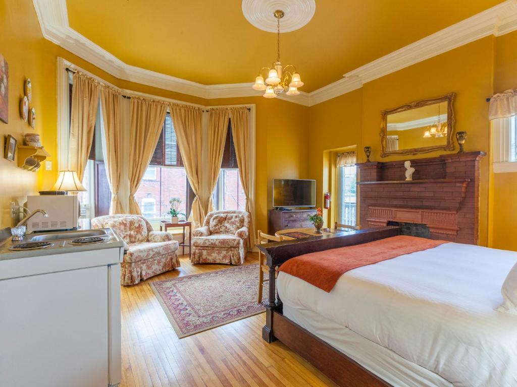 um quarto com paredes amarelas, uma cama e um lavatório. em Chipman Hill Suites - Sydney Street em Saint John