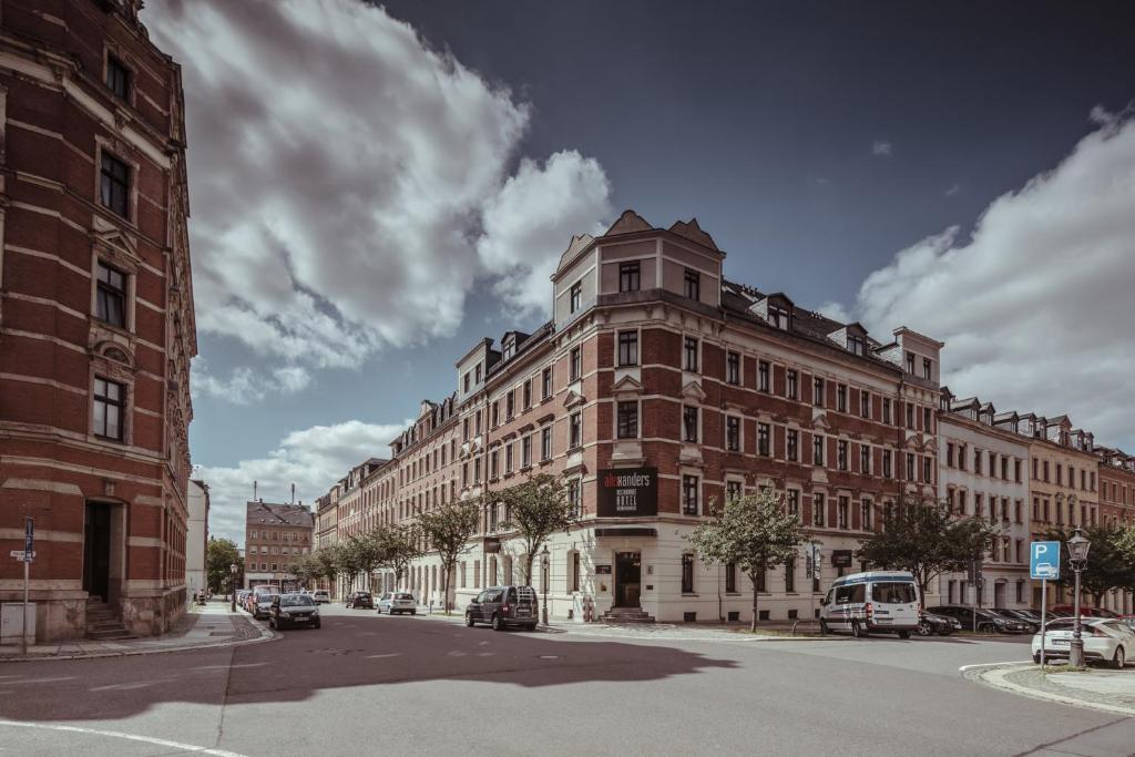 ein großes Gebäude an einer Stadtstraße mit vor der Tür geparkt in der Unterkunft alexxanders Hotel & Boardinghouse, Restaurant in Chemnitz