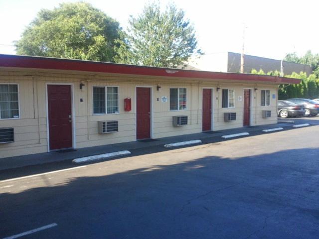 a building with red doors and windows on a street at Aaron Motel in Portland