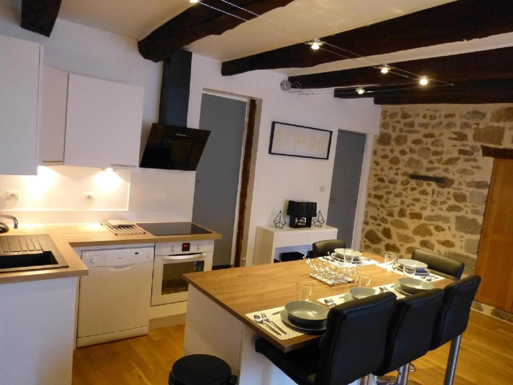 een keuken met een tafel en stoelen in een kamer bij le zola in Figeac