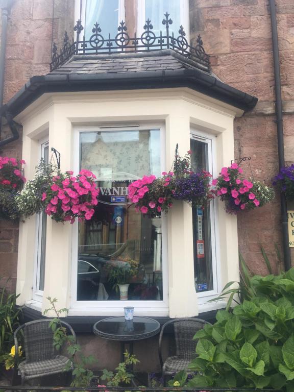 una finestra con fiori rosa su un edificio di Ivanhoe Guest House a Inverness