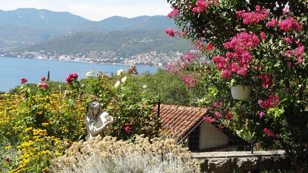 a statue of a woman in a garden with flowers at Dada Apartment in Rijeka