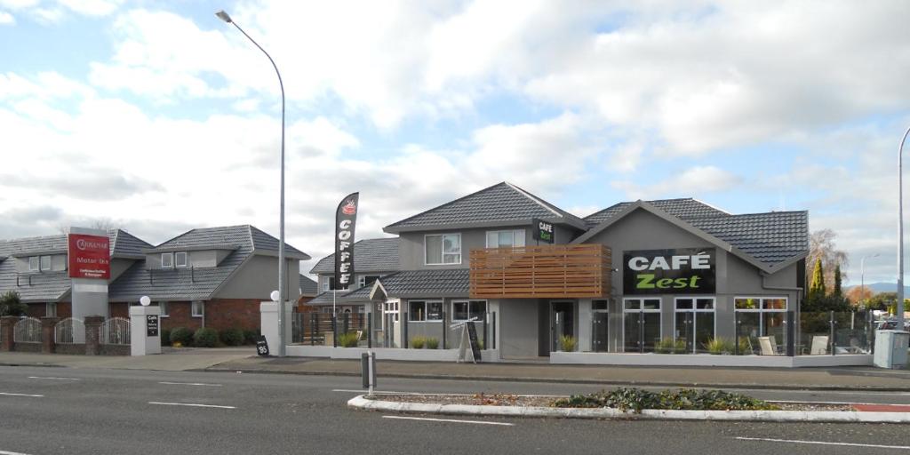 un restaurante cafetería al lado de una calle en Carramar Motor Inn, en Palmerston North