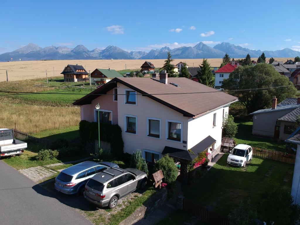 a house with two cars parked in front of it at Penzion Veronika in Štrba