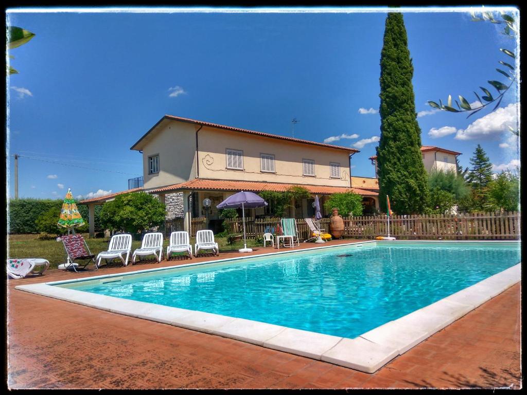 une piscine avec des chaises et une maison en arrière-plan dans l'établissement Residence il Colle, à Collestrada