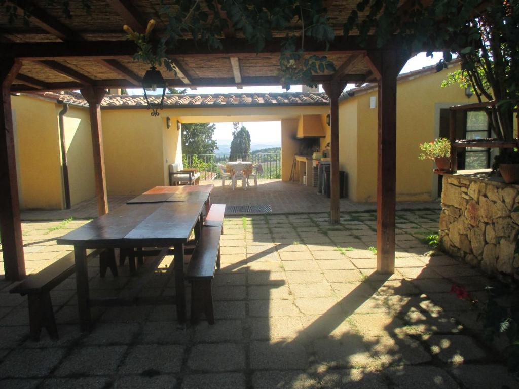 a patio with a wooden table and a pergola at Agriturismo Stigliano in Sarteano