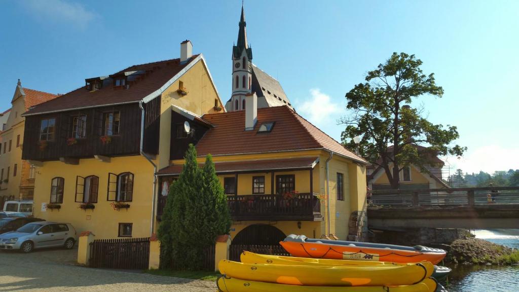 a church with two boats in front of a building at Hostel Merlin in Český Krumlov