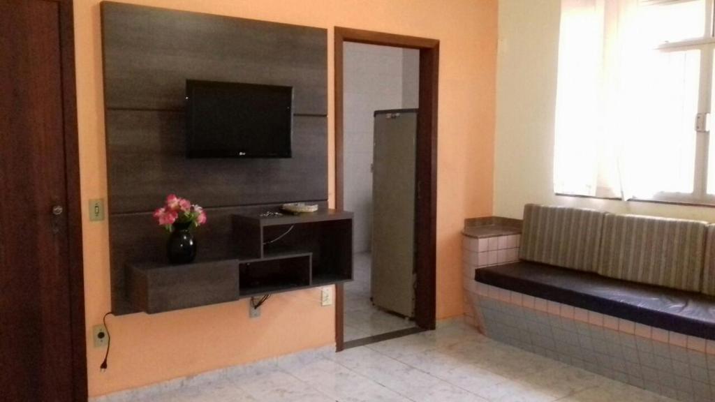 uma sala de estar com uma televisão e um sofá em Apartamento em Piúma-ES em Piúma