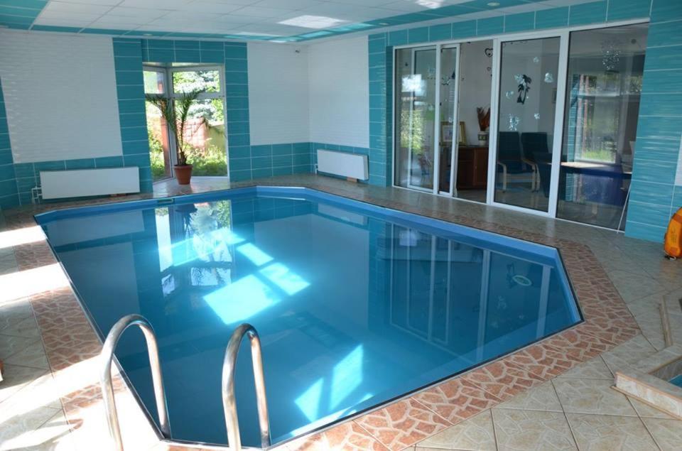 a large swimming pool with a blue tiled floor at Willa Cosmos & Champion in Iława