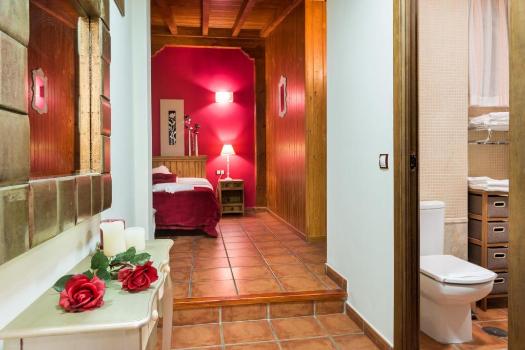 a bathroom with a toilet and a room with a bed at Hostal Restaurante Rijujama in Matillas