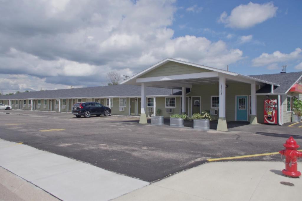 um edifício com uma boca de incêndio vermelha num parque de estacionamento em Economy Inn McCook em McCook