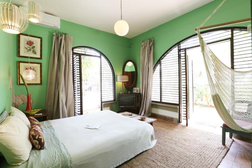 een slaapkamer met groene muren en een schommelbed bij DREAMCATCHER by DW in San Juan