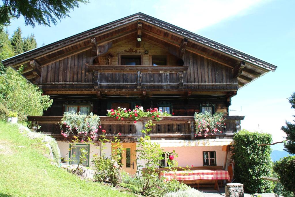 une maison avec des fleurs à l'avant dans l'établissement Das Pumphaus, à Brandenberg