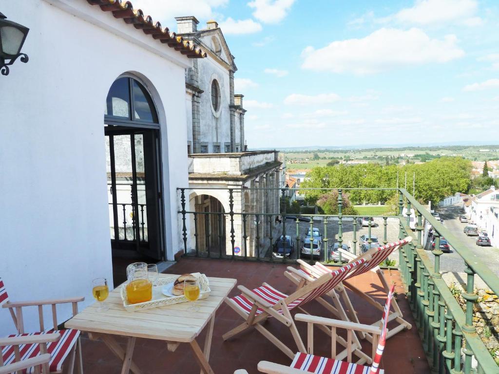 a patio with chairs and a table on a balcony at CASA DO LARGO DO COLÉGIO in Évora