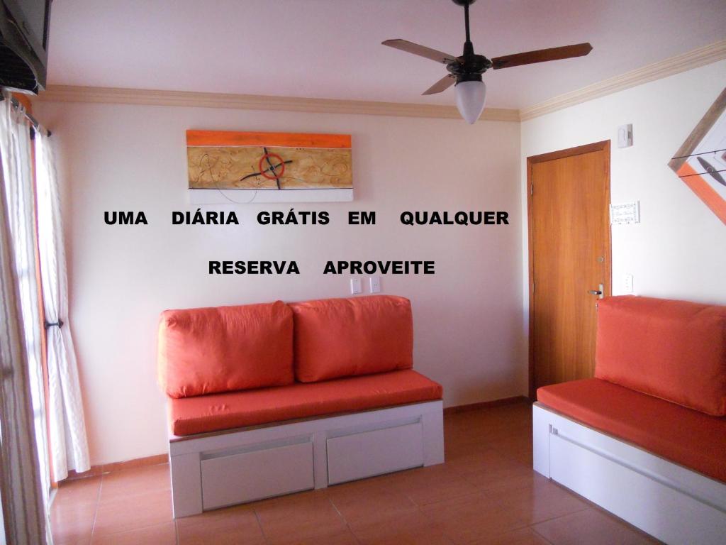 a waiting room with two red seats and words on the wall at Rio das Ostras Apartment in Rio das Ostras