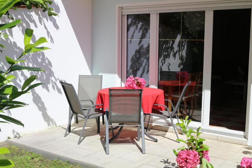 un tavolo e sedie su un patio con fiori rosa di Ferienwohnung Nienhagen a Ostseebad Nienhagen