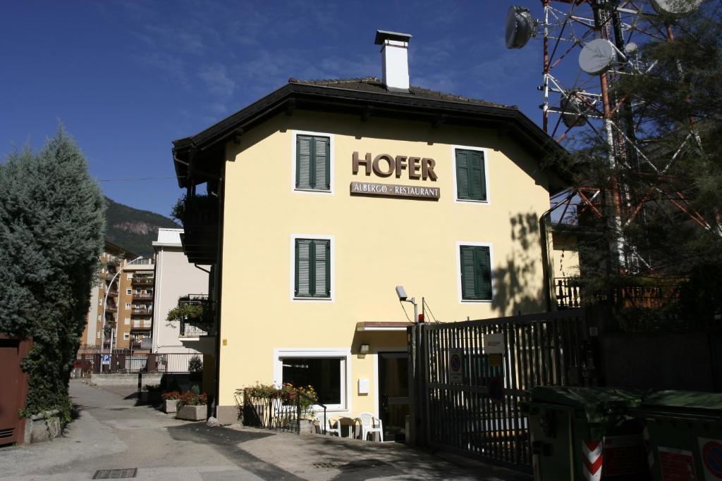 Ein weißes Gebäude mit einem Schild drauf. in der Unterkunft Albergo Hofer in Bozen