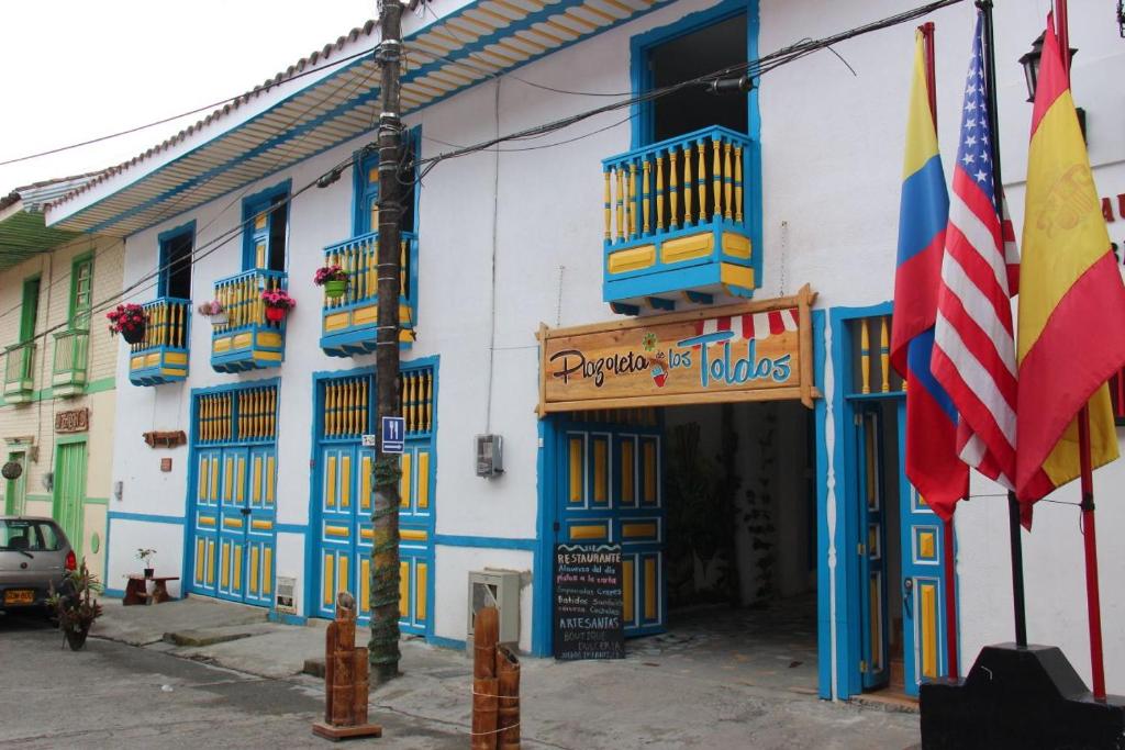 a building with blue and white walls and a flag at Apartahotel Calle del tiempo detenido in Filandia