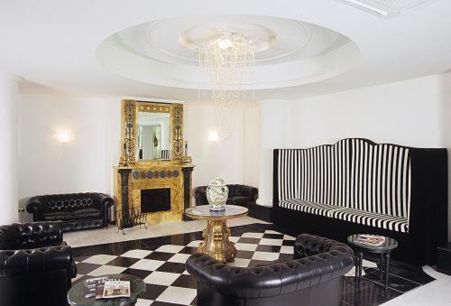 - un salon avec un mobilier en cuir noir et un miroir dans l'établissement M Glamour Hotel, à Gabicce Mare