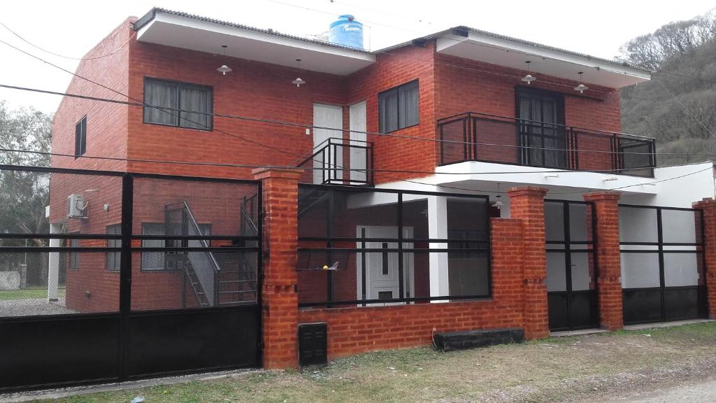 a red brick house with a black fence at Apartamentos Villa Jardin in Reyes