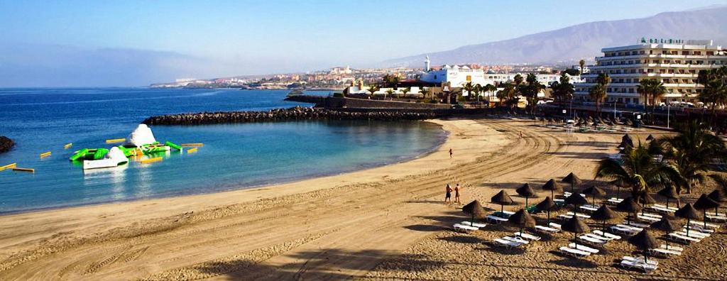 una spiaggia con ombrelloni e sedie e l'oceano di Atlantic Ocean View ad Adeje