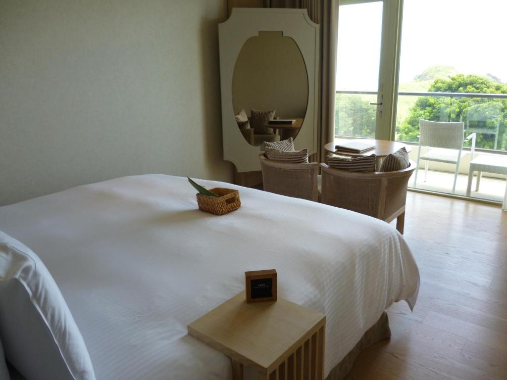 a bedroom with a bed with a mirror and a table at Gloria Manor in Kenting