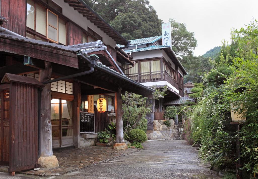 a street in front of a building with a house at Ryokan Adumaya in Hongu