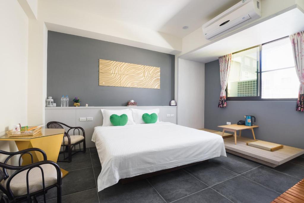 a bedroom with a bed and a table and chairs at Zhizhu Homestay in Tainan