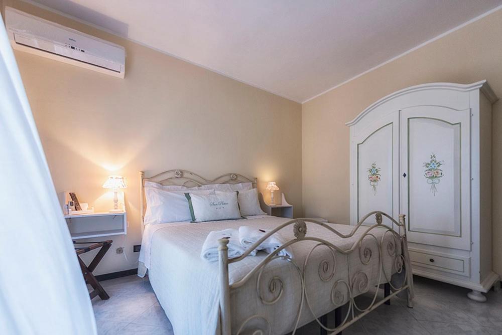 een slaapkamer met een wit bed en een witte kast bij San Pietro in Noto
