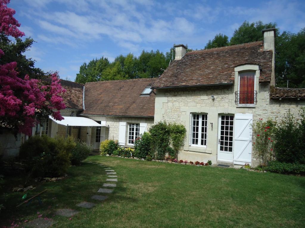 an old stone house with a grass yard at Le refuge du Pinail in Vouneuil-sur-Vienne