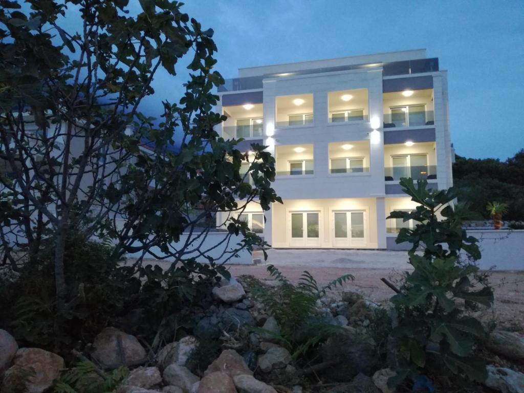 a large white building with lights on at Apartments Villa Hadria in Makarska