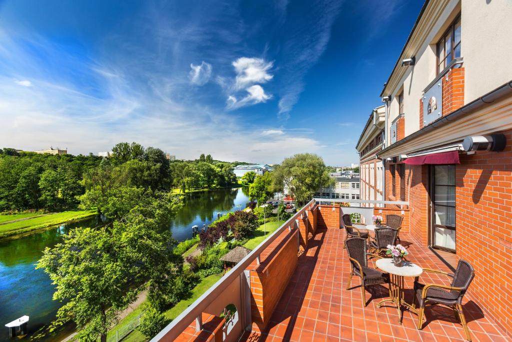 a balcony with a view of a river at Hotel Słoneczny Młyn in Bydgoszcz