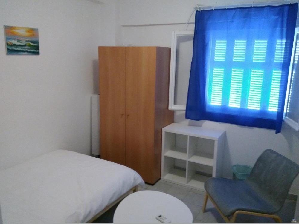 アテネにあるArtemidos Apartmentのベッドルーム1室(ベッド1台、椅子、窓付)