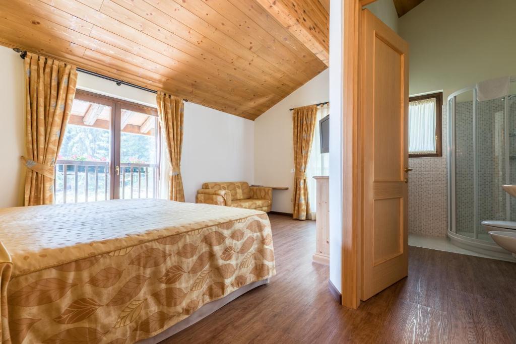 a bedroom with a bed and a large window at La capr'allegra in Gallio